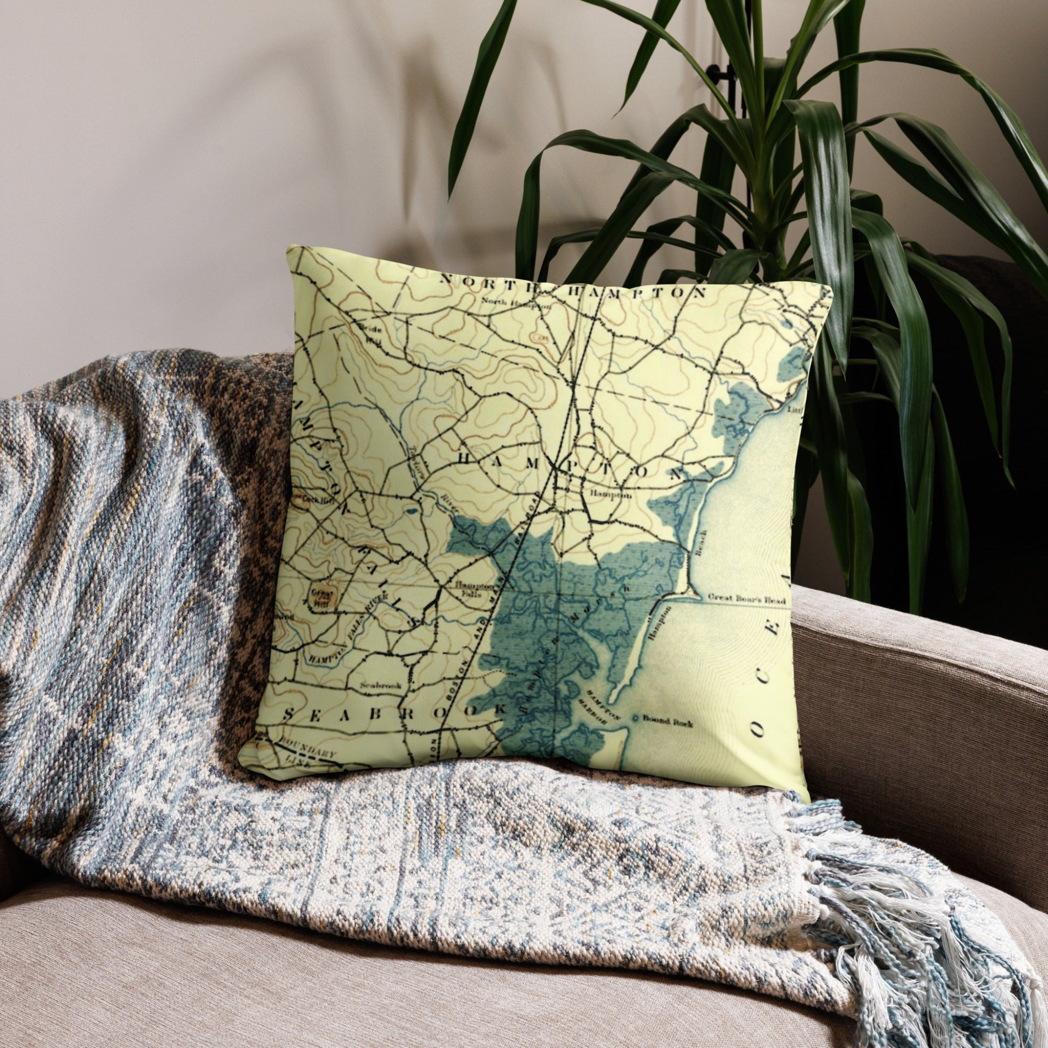 Map pillow on a couch with a plant in the background