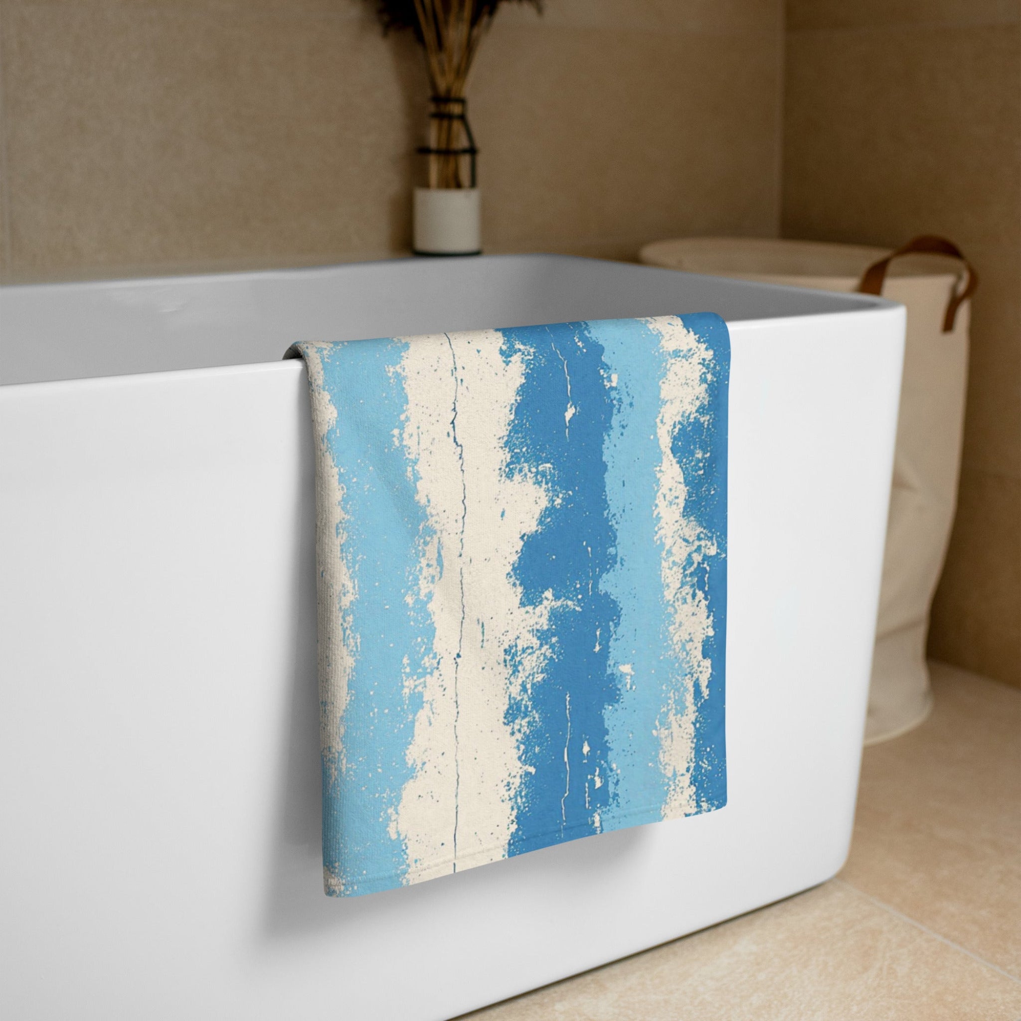 Blue and beige striped towel draped over a white bathtub.