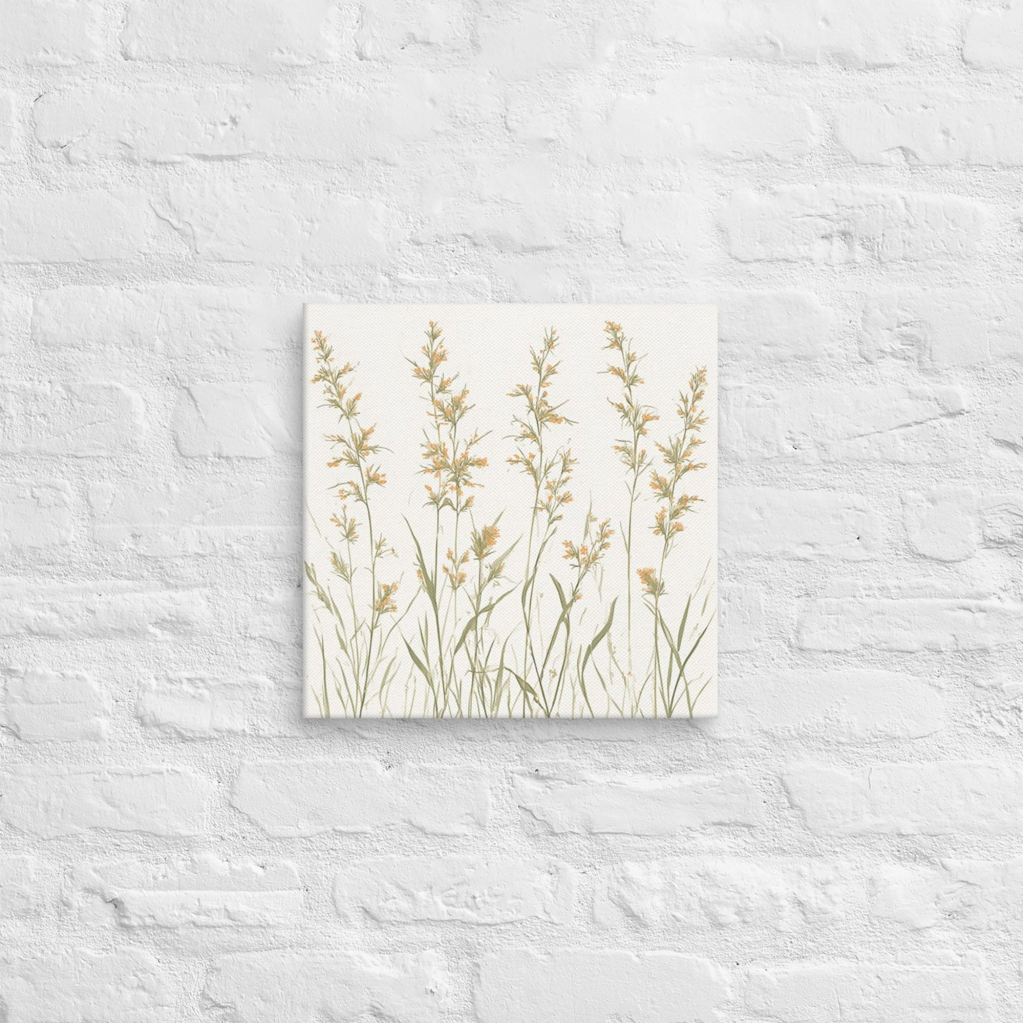 A square canvas print featuring minimalist illustrations of delicate, neutral-toned meadow grasses and wildflower stems on a cream background on a textured white wall