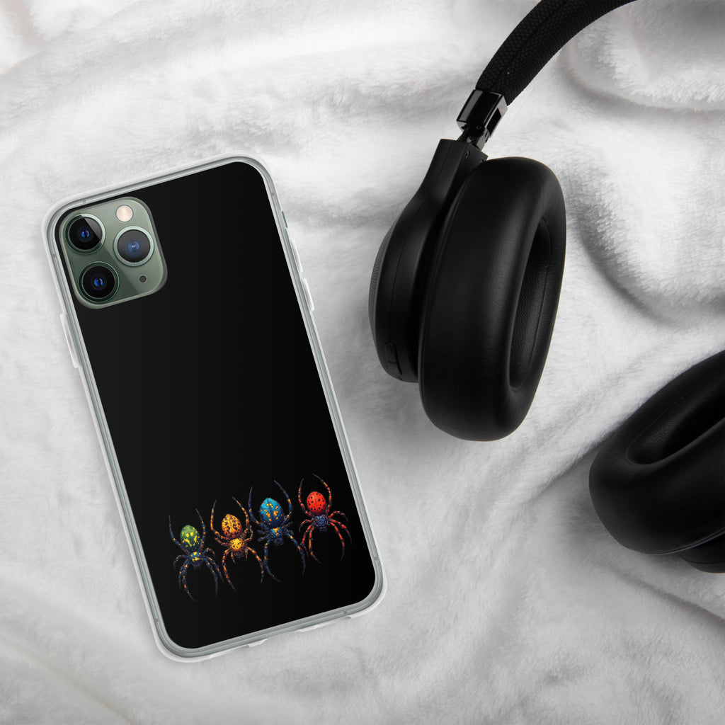 Iphone case with a color spider design laying on white towel beside black headphones.