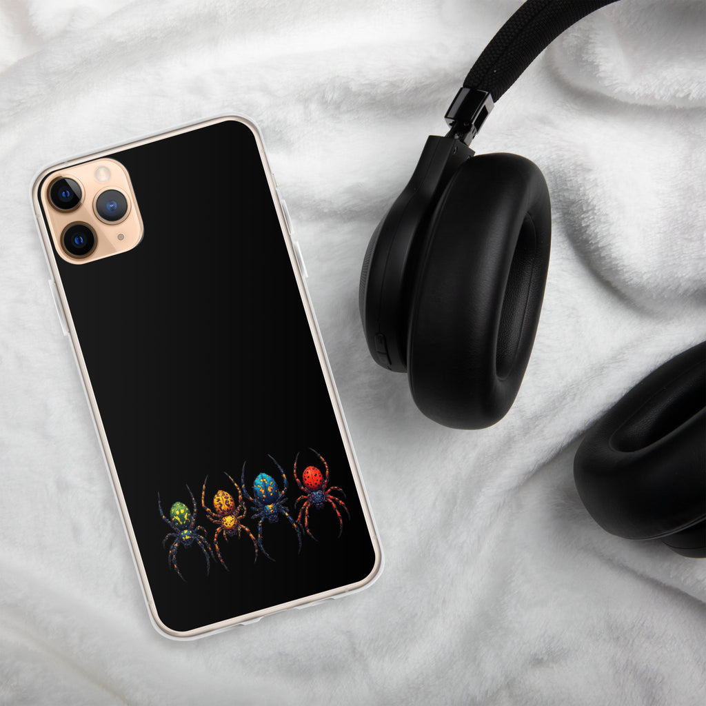 A black phone case with a colorful spider graphic, shown on a smartphone next to black headphones on a white textured blanket background.