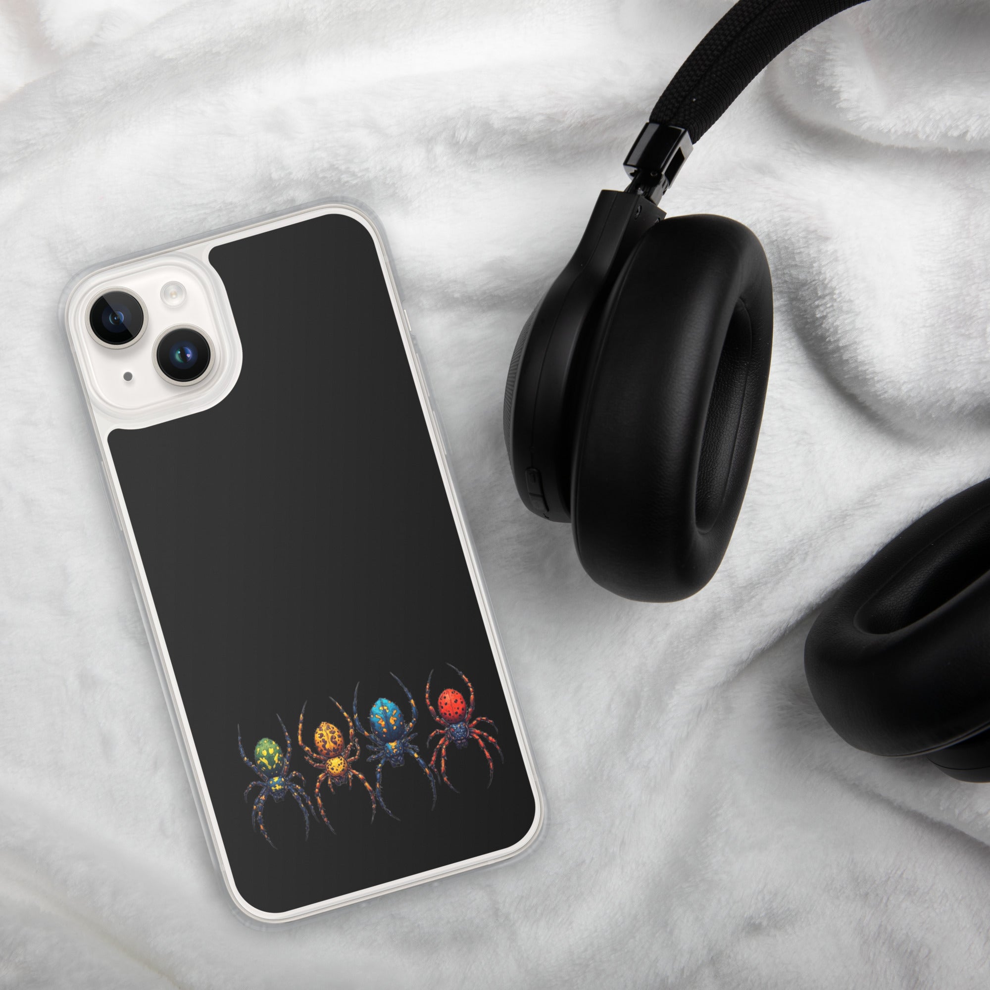Phone case with colorful spider design on a textured surface with headphones.