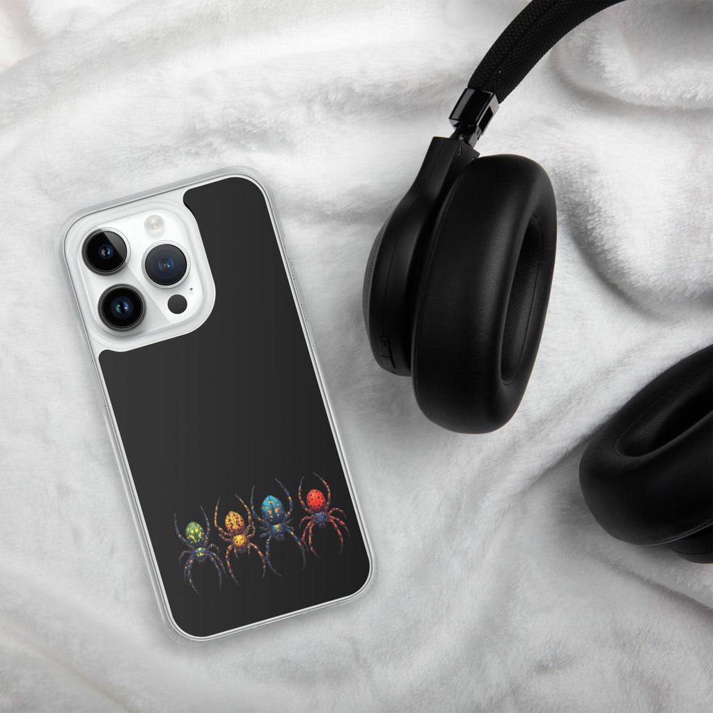 A clear-edged smartphone case with a black back panel and a colorful spider graphic, shown on a white textured blanket next to black headphones.