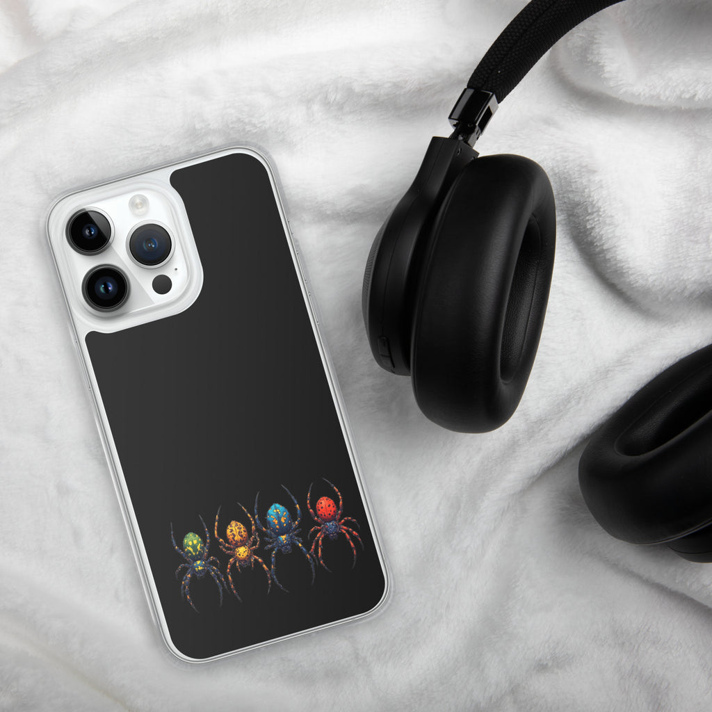 A clear-edged smartphone case with a black back panel featuring a row of colorful spiders near the bottom, shown on a white textured fabric surface next to black headphones.