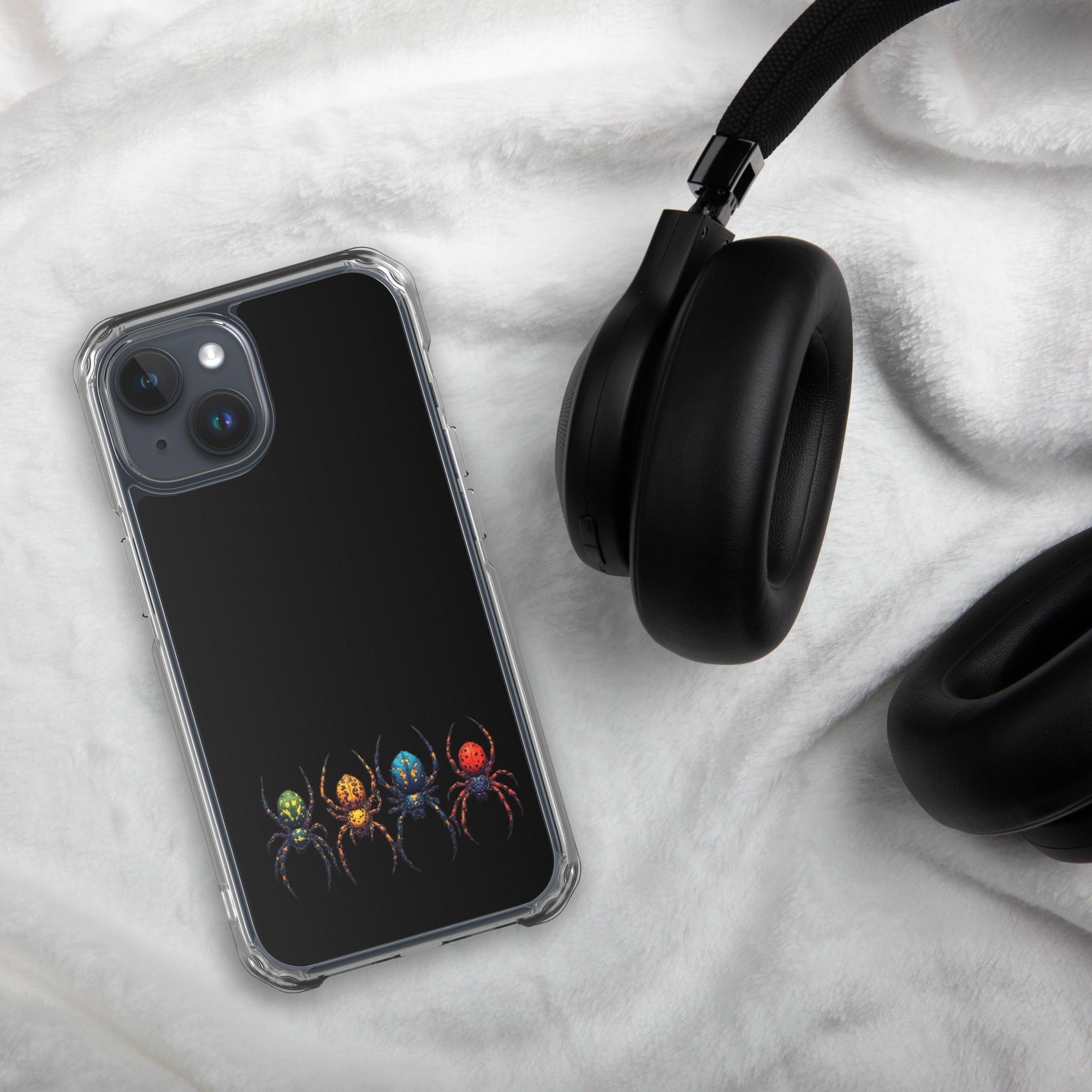 Phone case with colorful spider design on a marble surface with headphones.