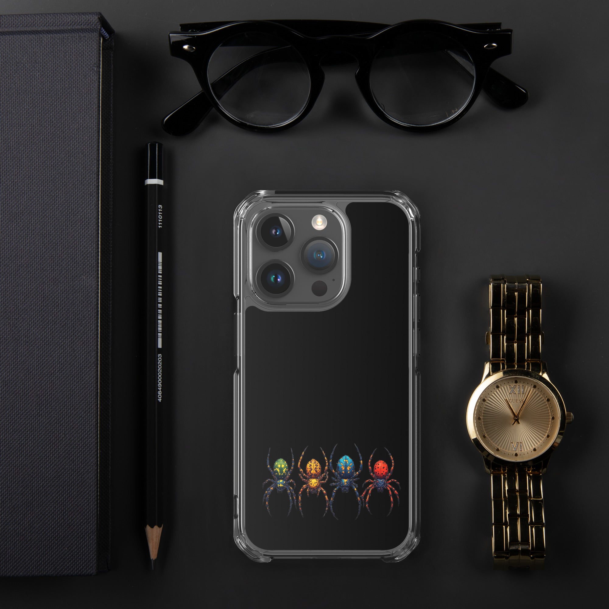 Iphone case with a color spider design laying on black desk with a pen watch a eye glasses laying next to the Iphone.