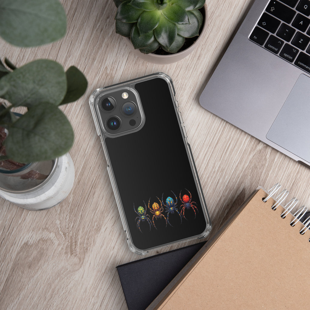 Phone case with spider design on a desk with laptop and plants