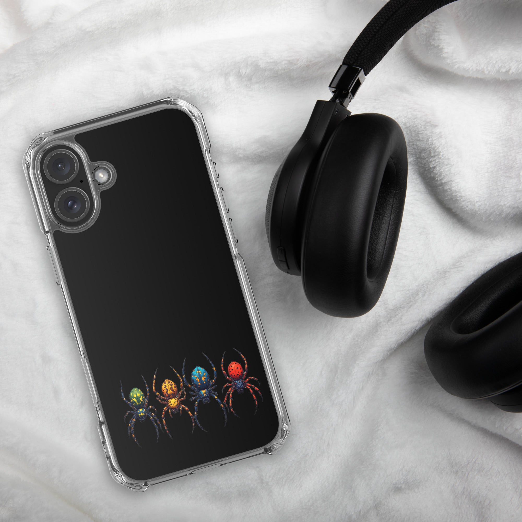 Phone case with colorful spider design on a textured surface with headphones.