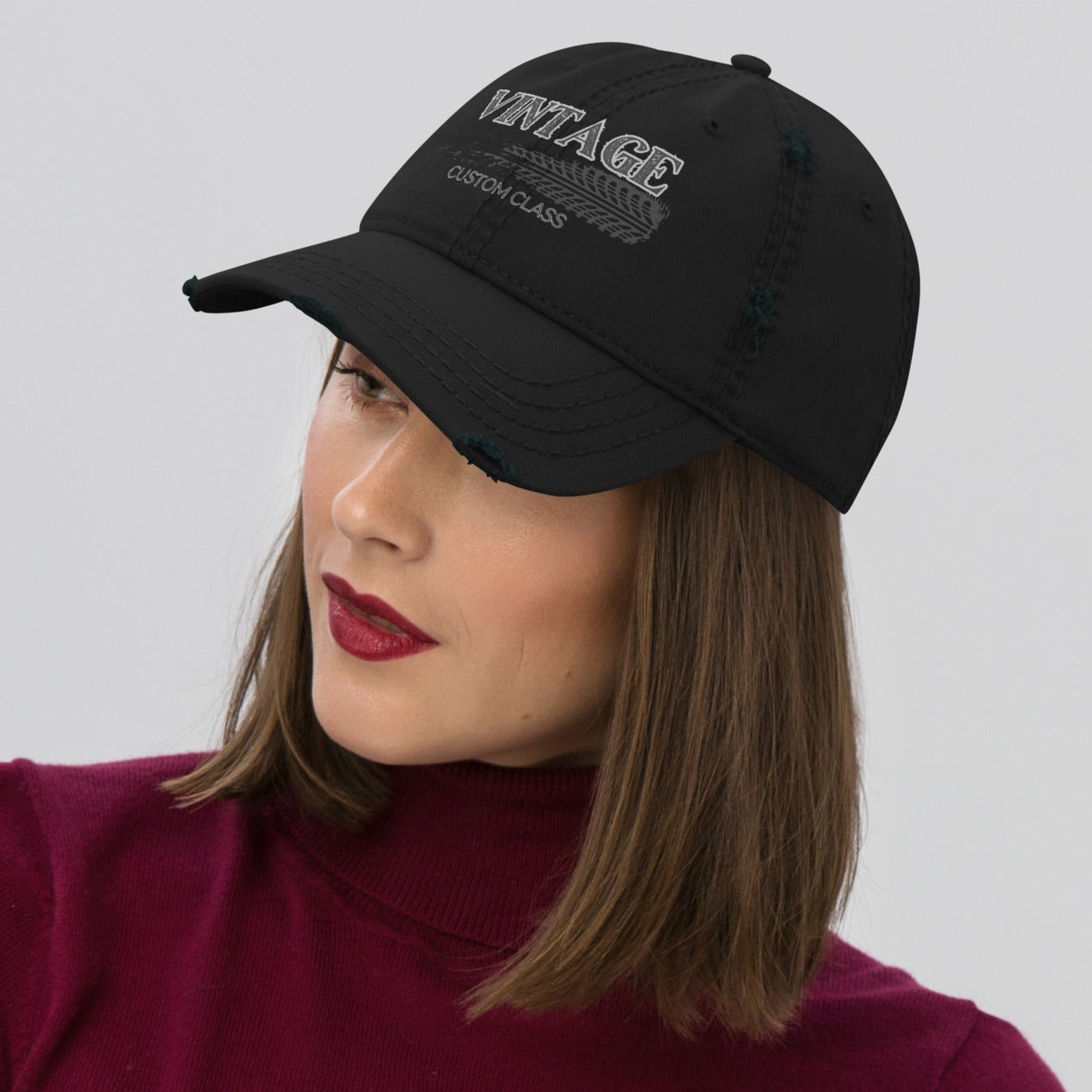 Woman wearing a black cap with 'Vintage custom class' text on a gray background.