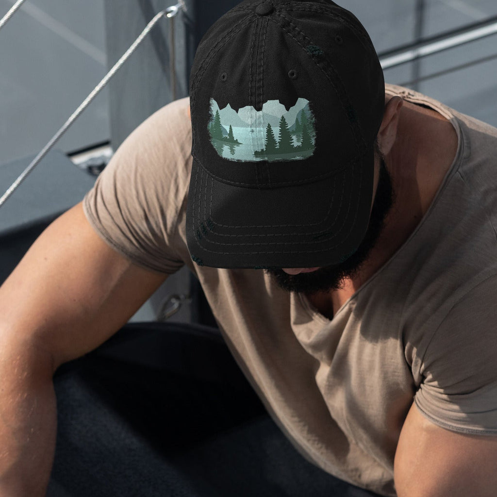 Man wearing a charcoal black dad hat with a fisherman lake scene graphic while out on a boat, casual outdoor fishing cap for men. 