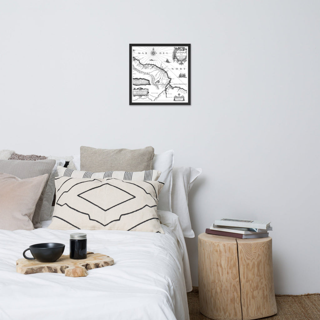 Bedroom with a bed, pillows, a small table, and a framed map on the wall.