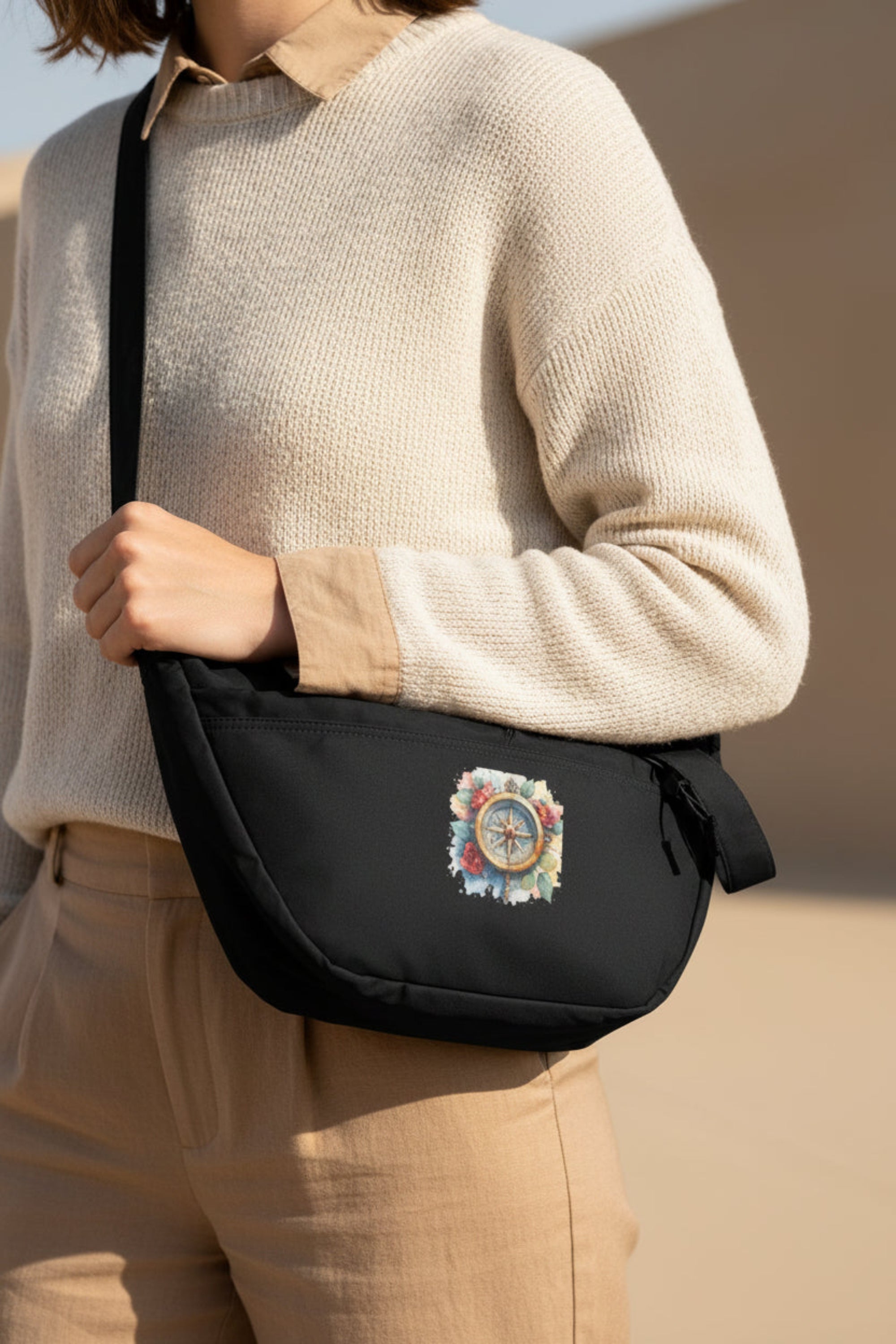 Black waist bag with a colorful compass design on a white background