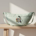 Light seafoam color crossbody bag with a colorful graphic on a white background.