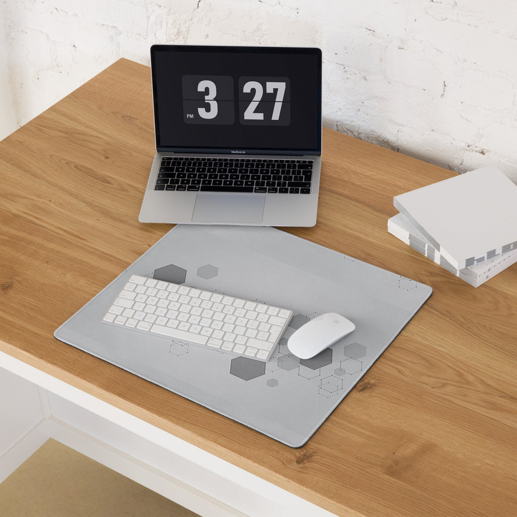 Laptop on a wooden desk with a digital clock display, mouse, and keyboard on a gray mouse pad.
