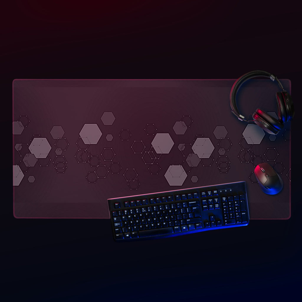 Gaming desk setup with a large mouse pad, keyboard, mouse, and headphones on a dark background.