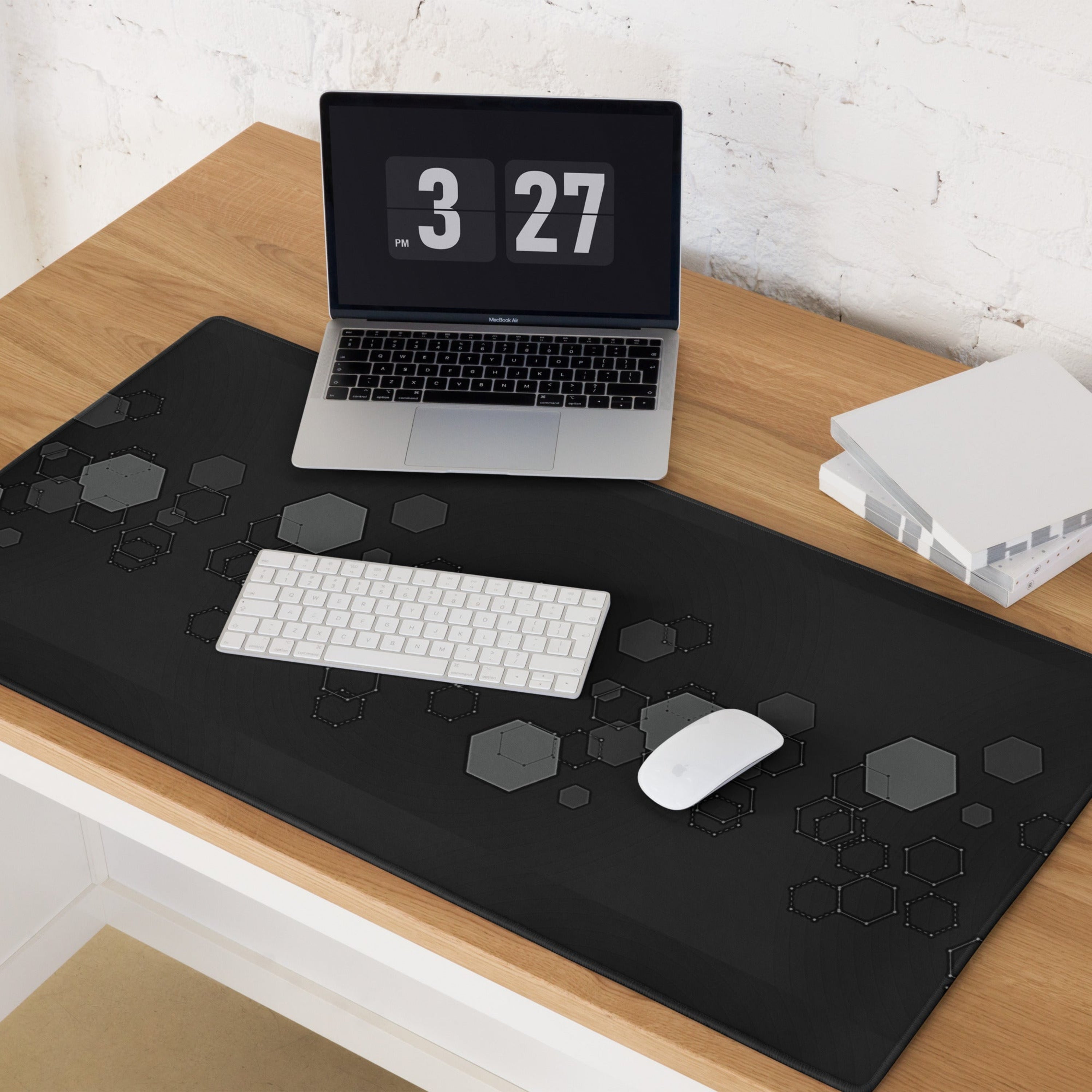 Laptop on a wooden desk with a large extended black Hexagon Geometric Design on Gaming Desk Mat, keyboard, and mouse.
