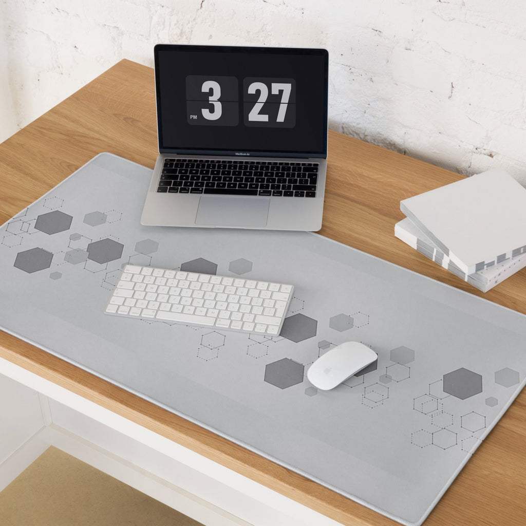 Laptop on a desk with a geometric patterned mouse pad. 
