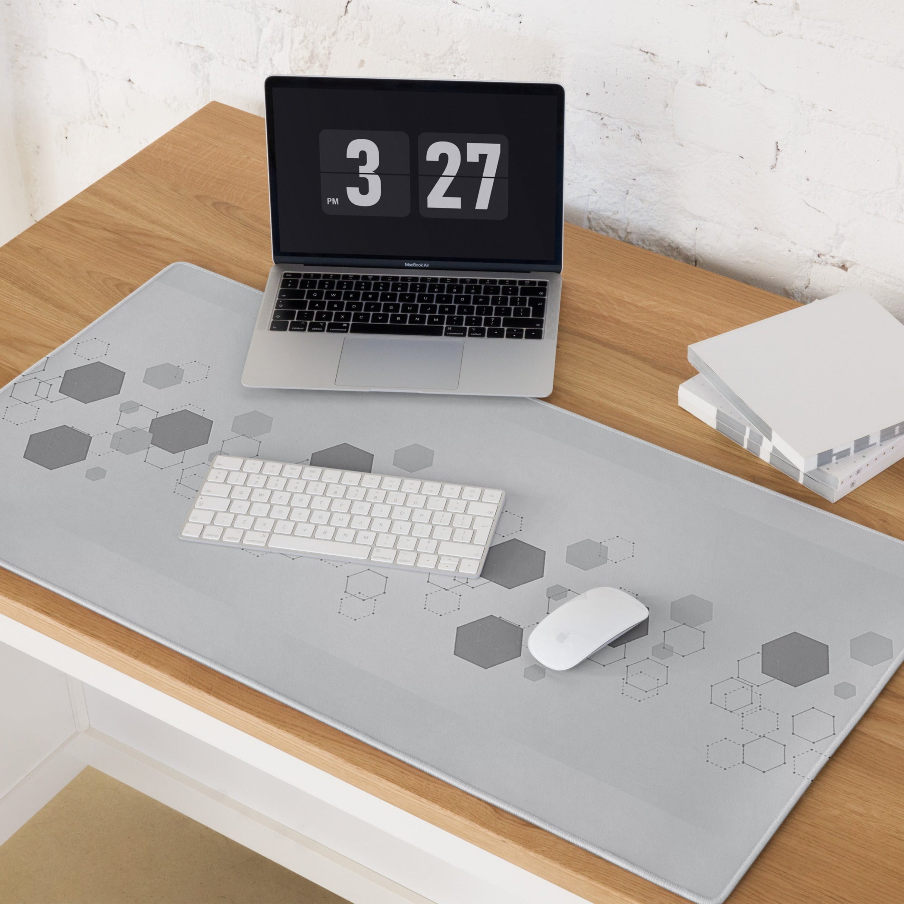 Laptop on a desk with a geometric patterned mouse pad. 