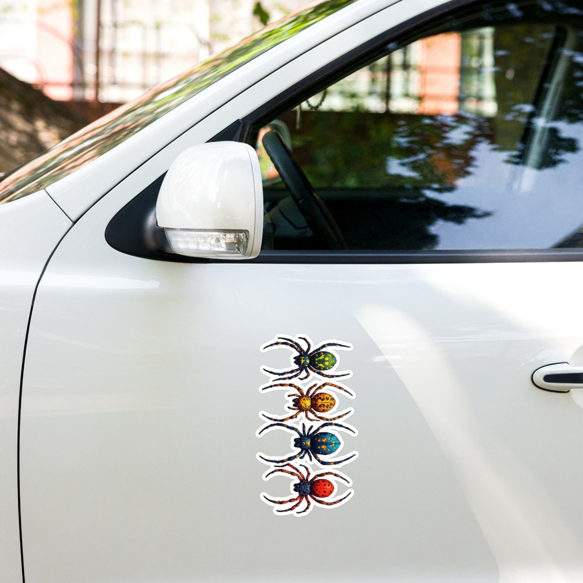 The outside of a white car door with a vinyl decal of colorful spiders.