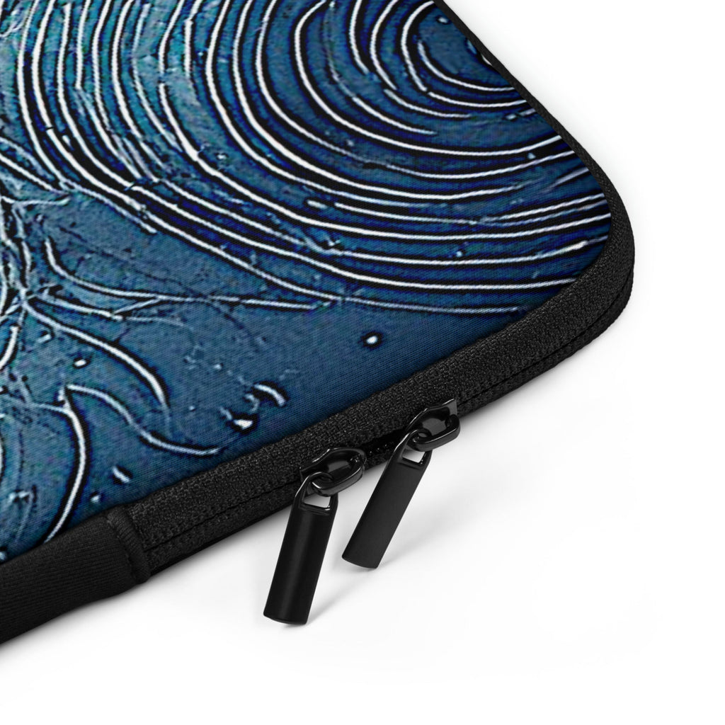 Close-up of a laptop sleeve featuring a textured blue and white swirling pattern, finished with black zippers and pull tabs, shown on a white background.
