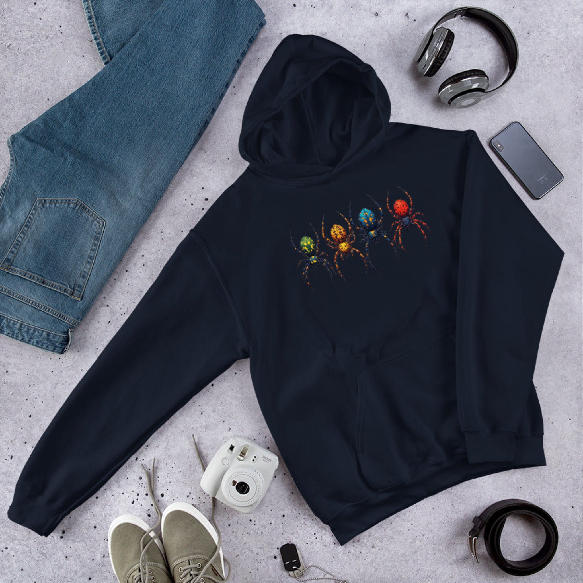 Dark Blue hoodie with a colorful spider design on a gray surface with jeans, shoes, and accessories.