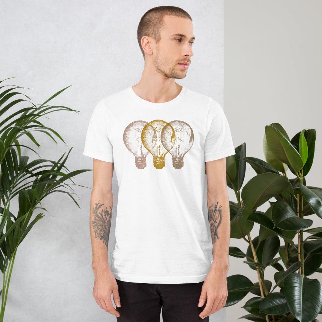 Man wearing a white t-shirt with an Edison light bulb design standing against a light gray background with plants.
