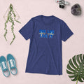 Blue t-shirt with 'ONE LIFE LIVE IT' text on a light pink background with shoes and decorative items.