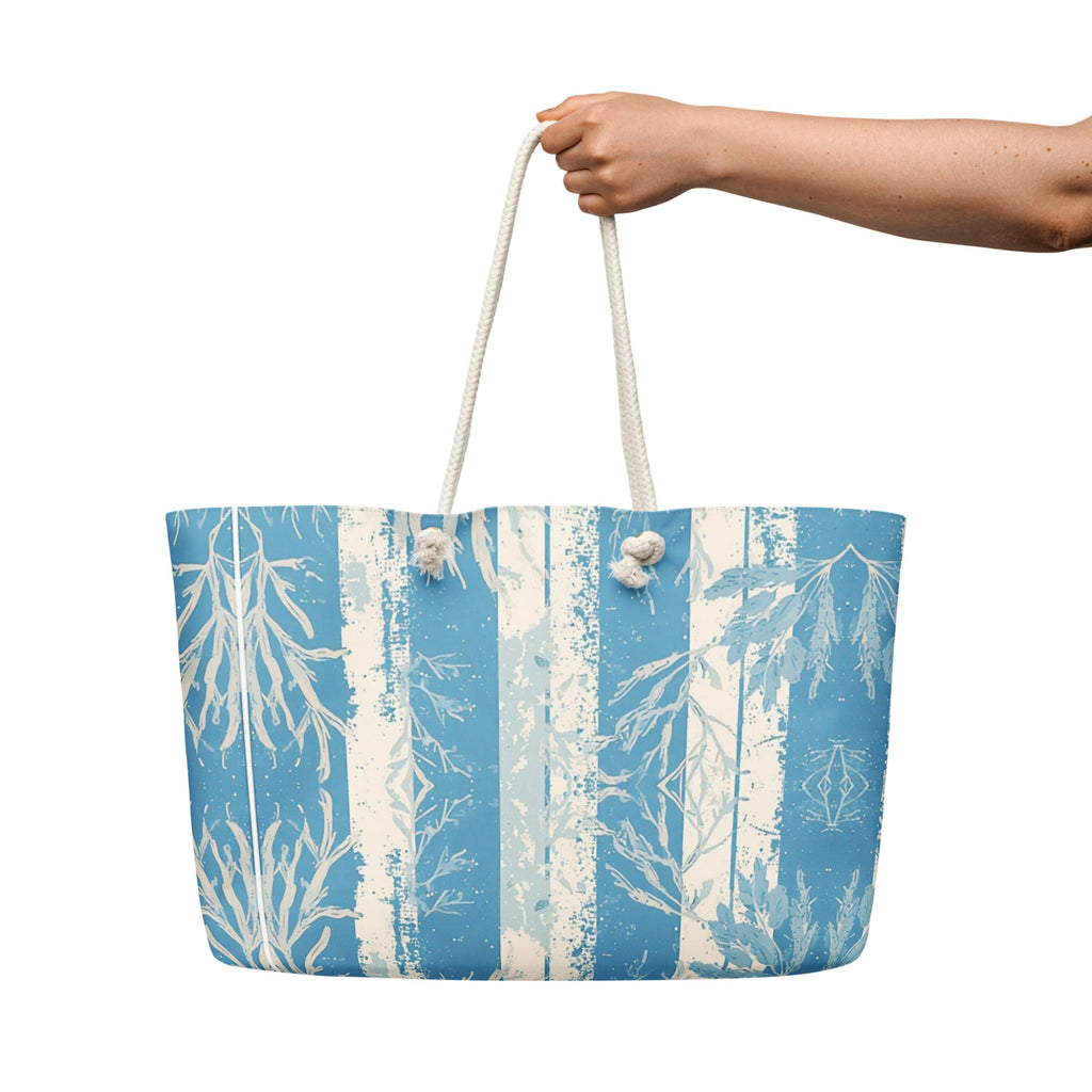 Tote bag with blue and white design held by a hand on a white background