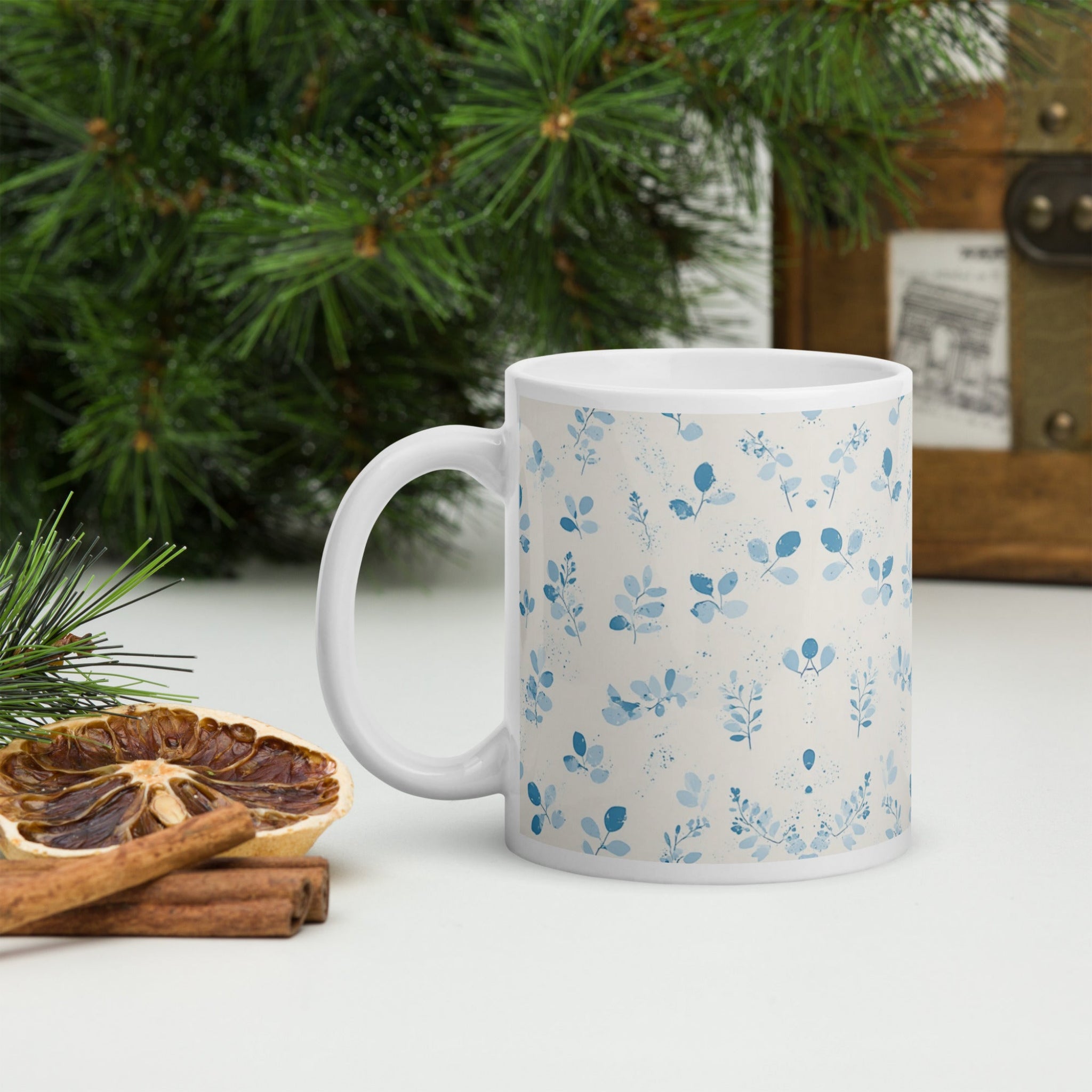 Two white mugs with blue floral patterns stacked on a white background