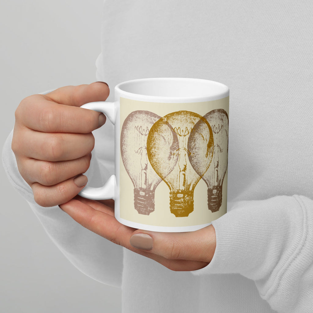 Hand holding a mug with light bulb design on a plain background