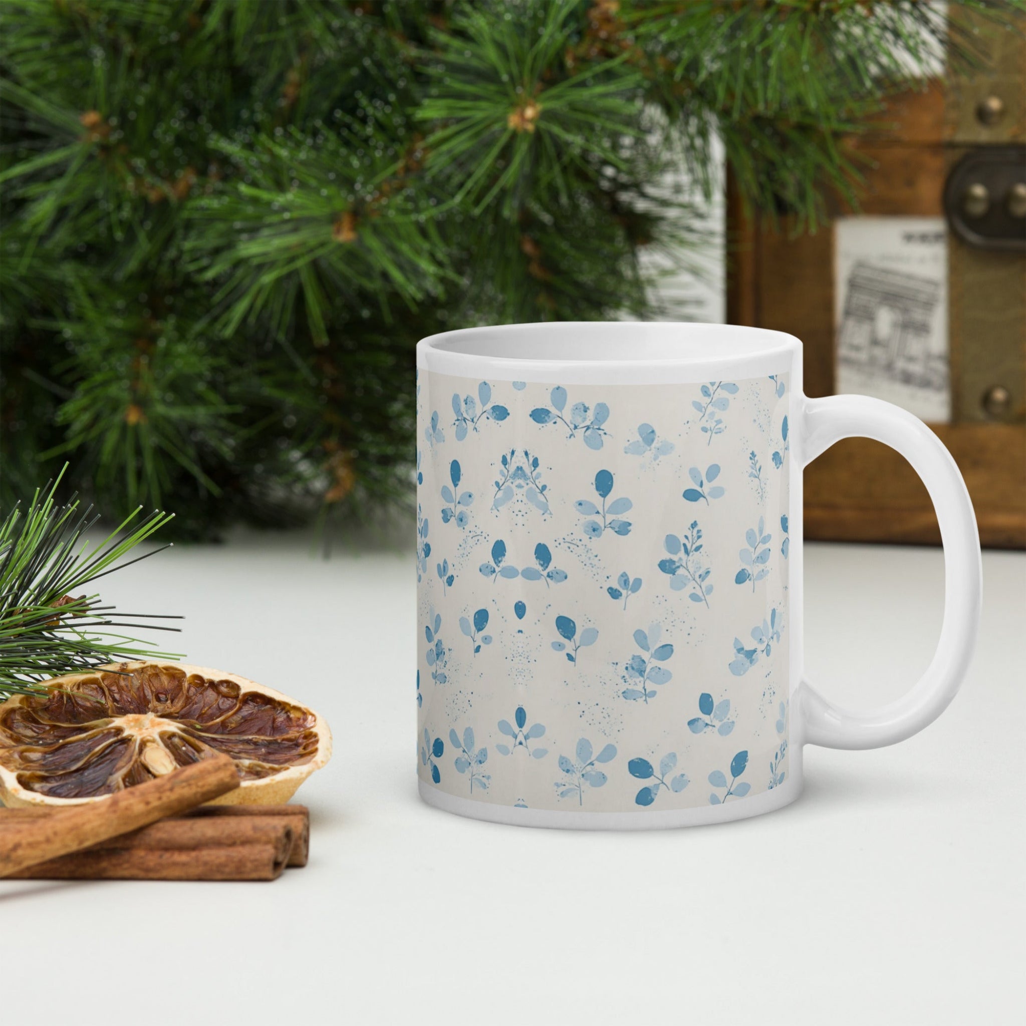 Two white mugs with blue floral patterns stacked on a white background
